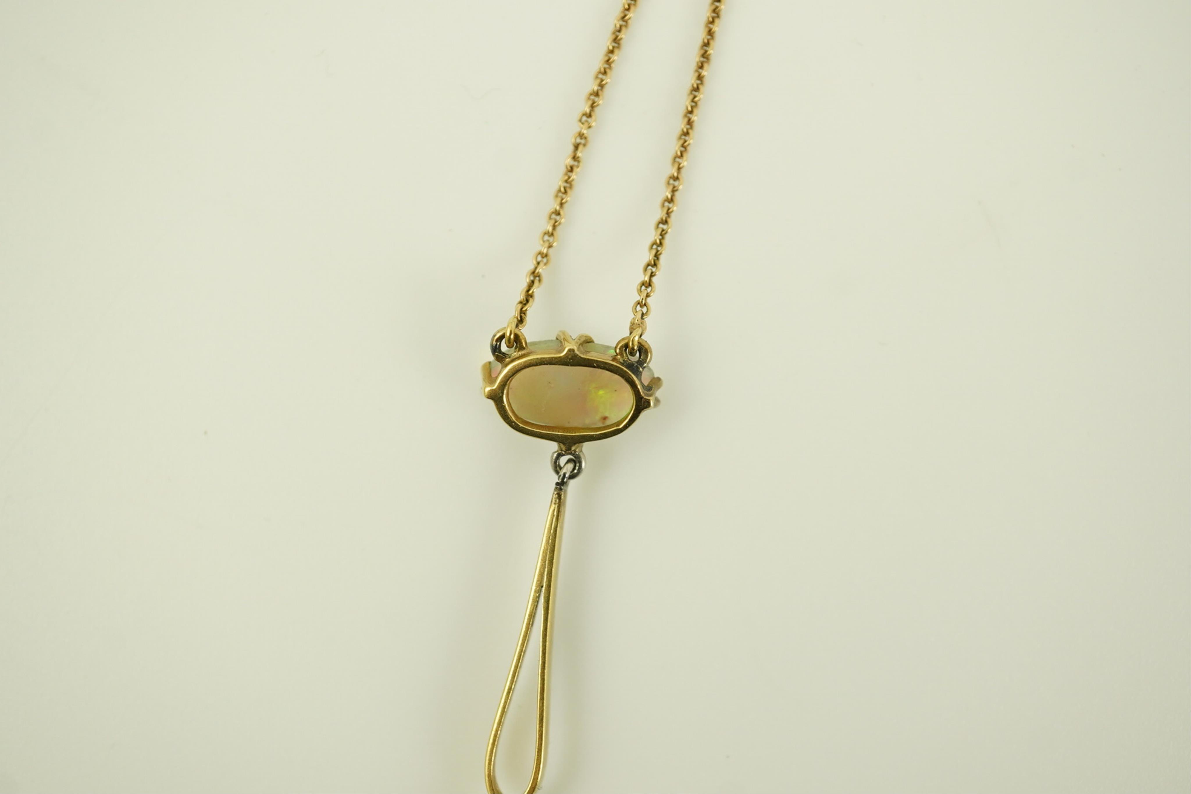 An early 20th century gold, two stone white opal and single stone diamond set drop pendant necklace